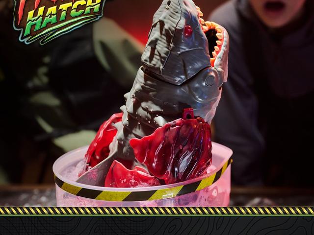 A Primal Hatch Megalodon shark rising from its egg in a tank